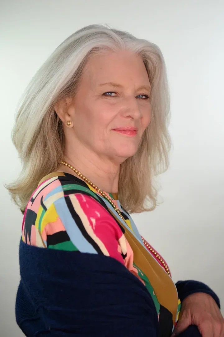 Patricia A. Tracy in a cheerful mood, wearing a deep neckline blue blouse.
