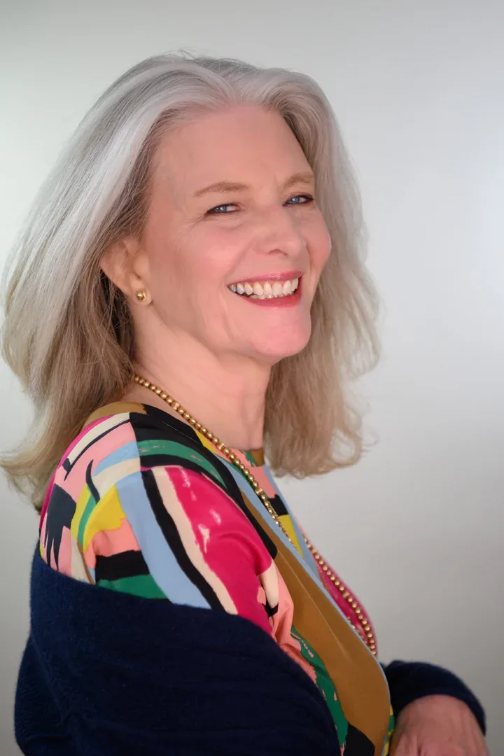 Patricia A. Tracy with a pleasant expression in a navy outfit with a sheer overlay.