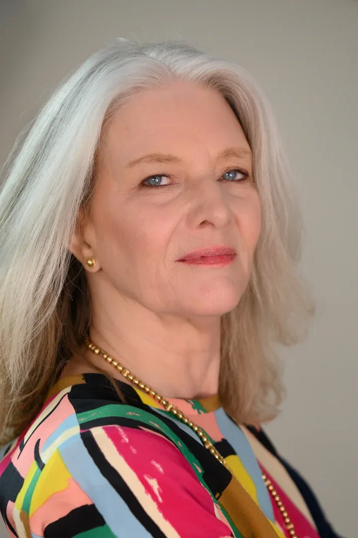 Patricia A. Tracy seated comfortably in a vibrant, patterned dress.