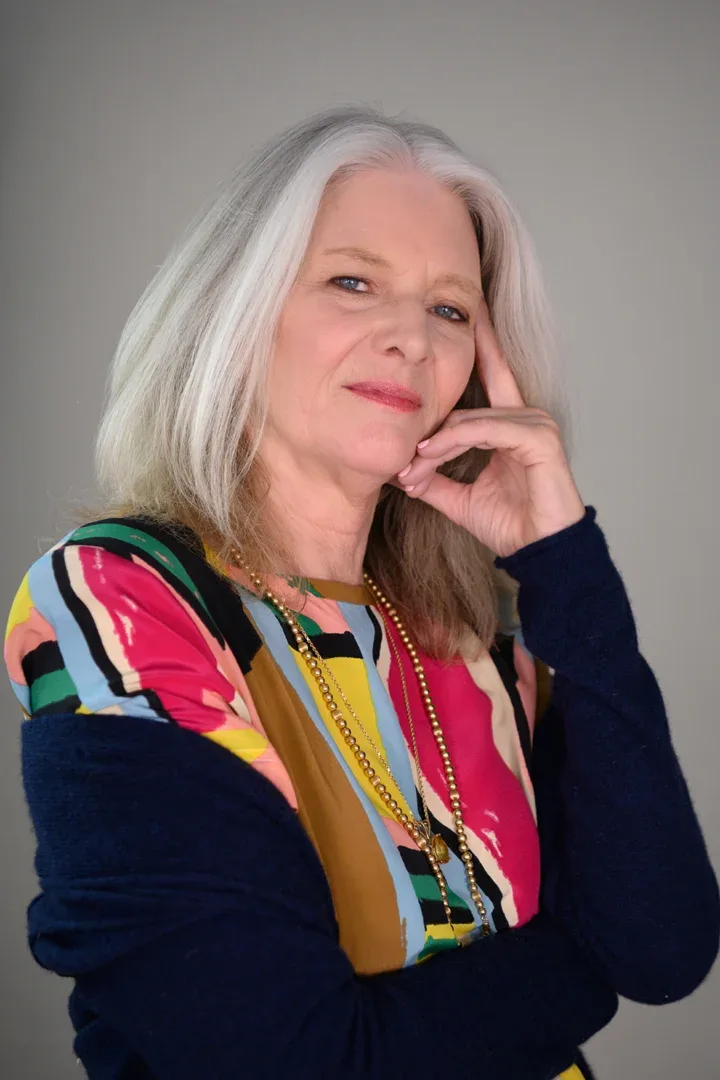 Patricia A. Tracy in a patterned dress, seated and content.