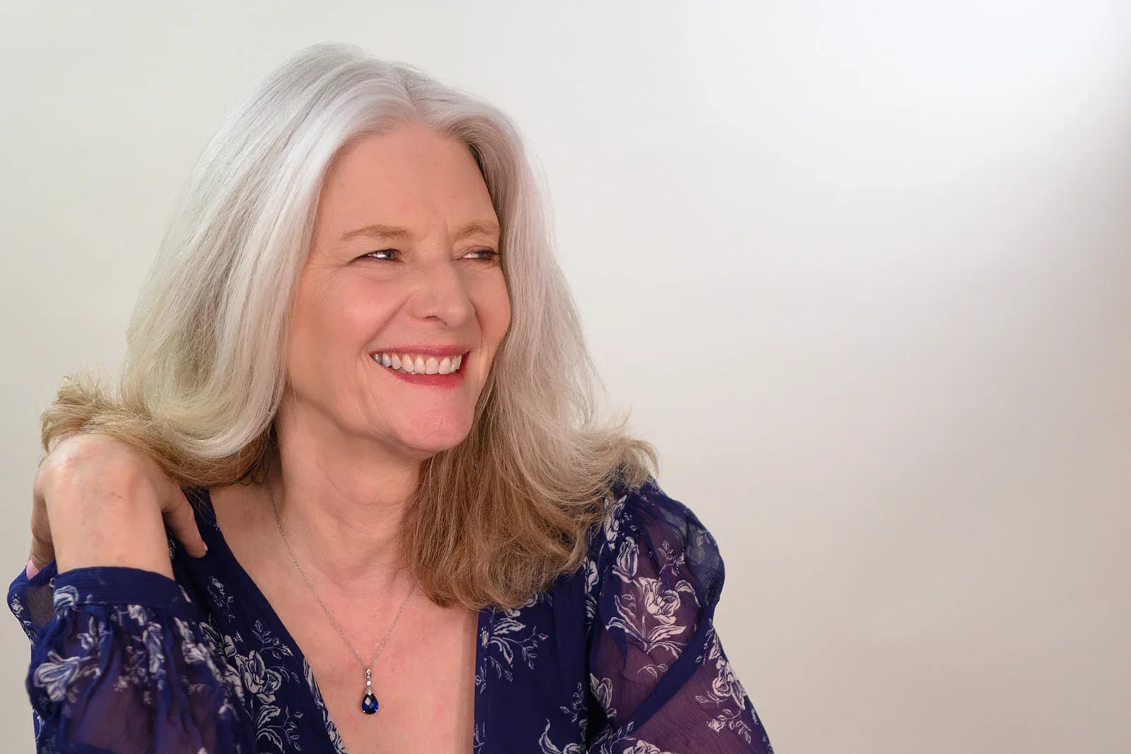 Patricia A. Tracy relaxed in a black and colorful abstract dress.