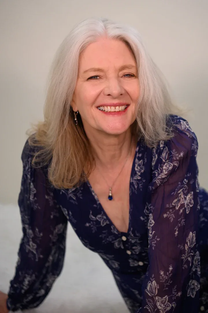 Patricia A. Tracy reclining with a wide smile in a colorful dress.