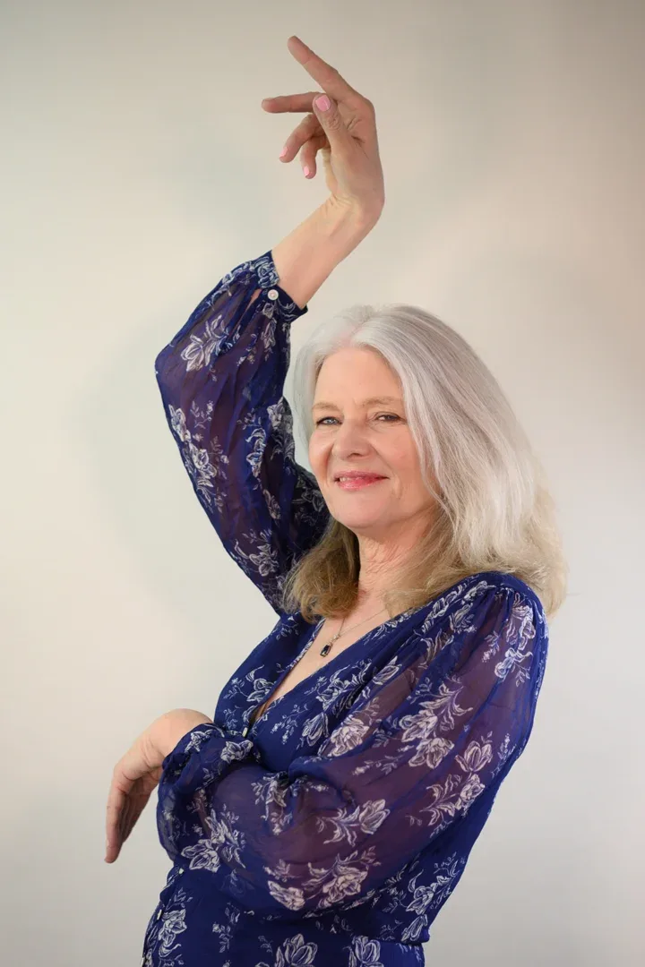 Patricia A. Tracy reclining with a wide smile in a colorful dress.